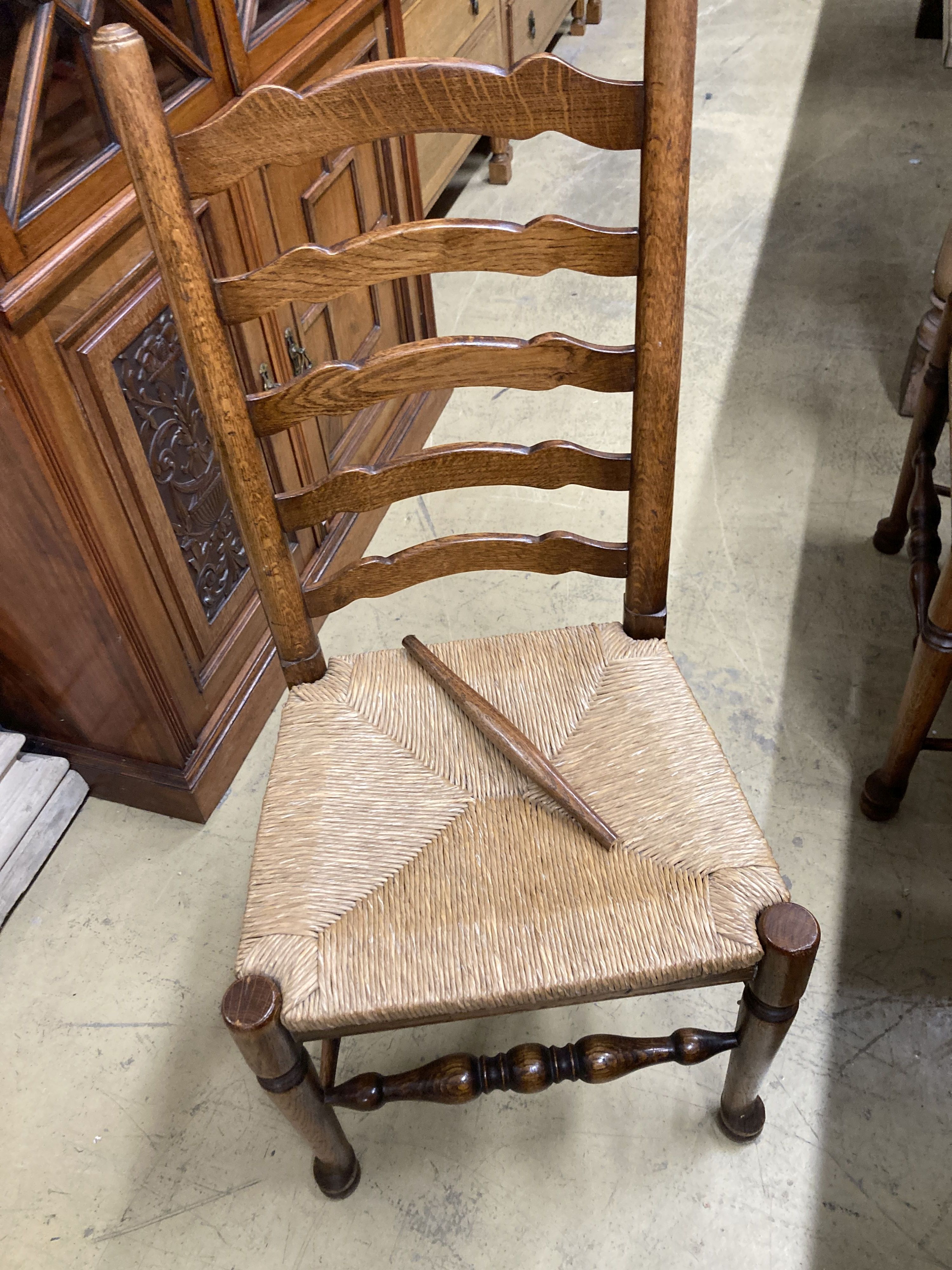 A set of eight 18th century style oak rush seat ladderback dining chairs, (two with arms)